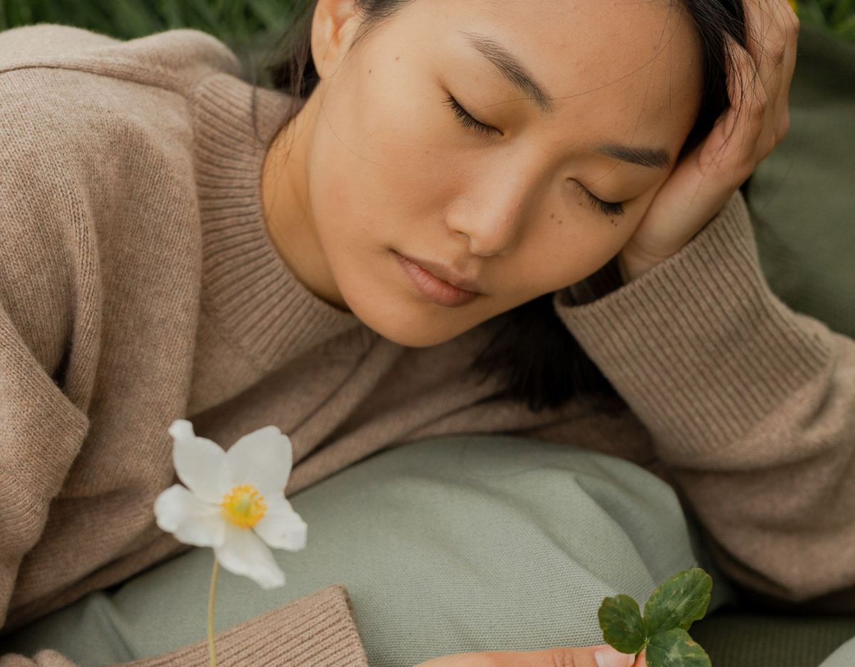 Frau liegt auf Decke mit Blumen