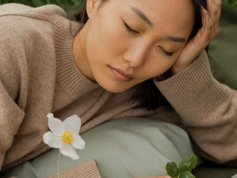 Frau liegt auf Decke mit Blumen