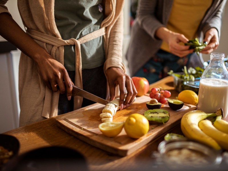 richtige Ernährung: Freundinnen bereiten Essen zu Ernährungsgewohnheiten