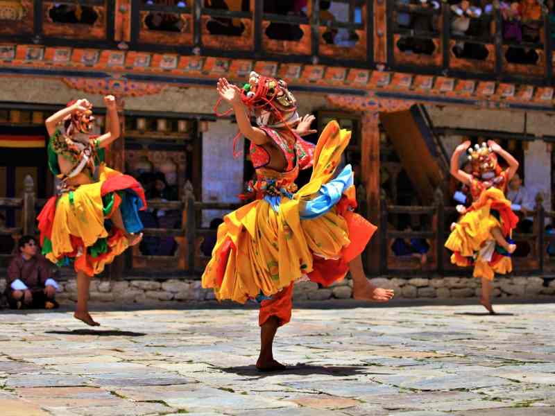 bhutan glücksindex tanzen menschen maske