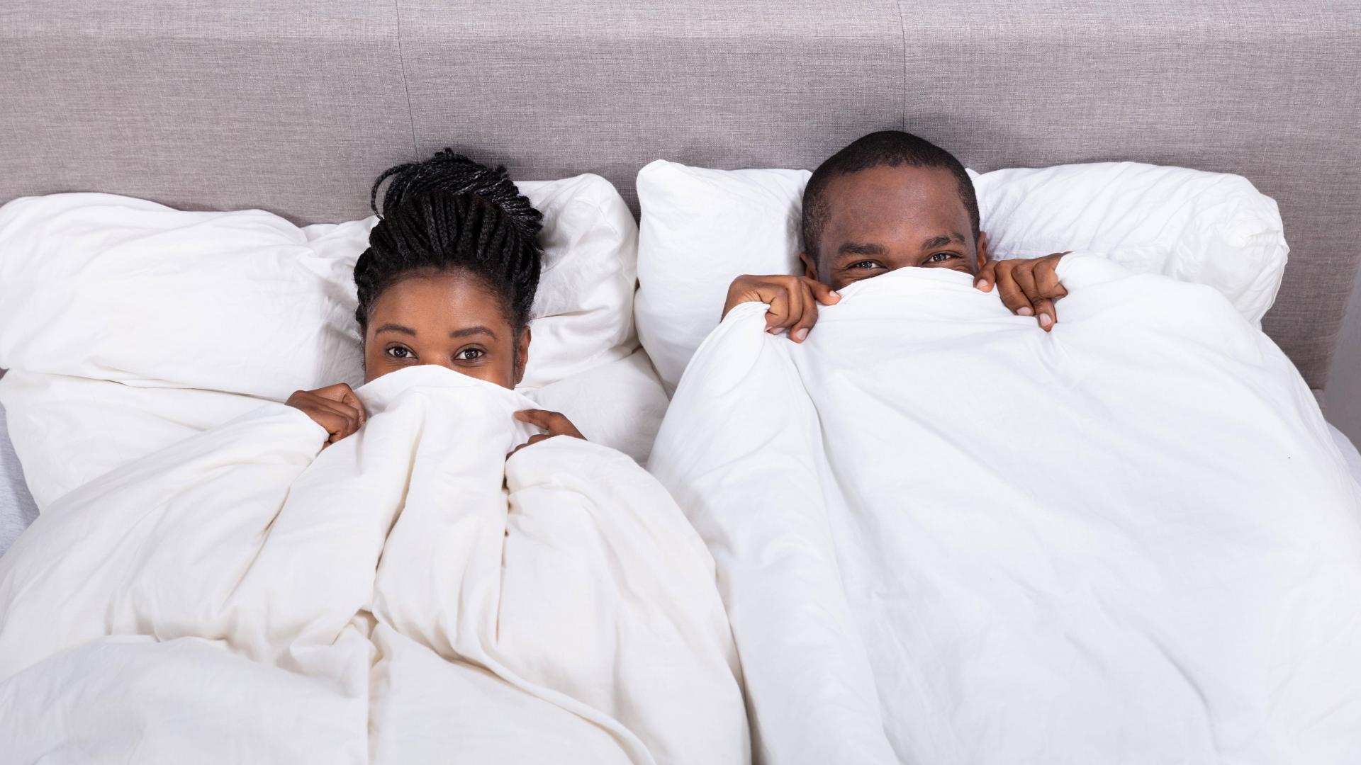 Pärchen im Bett, Decke über dem Kopf