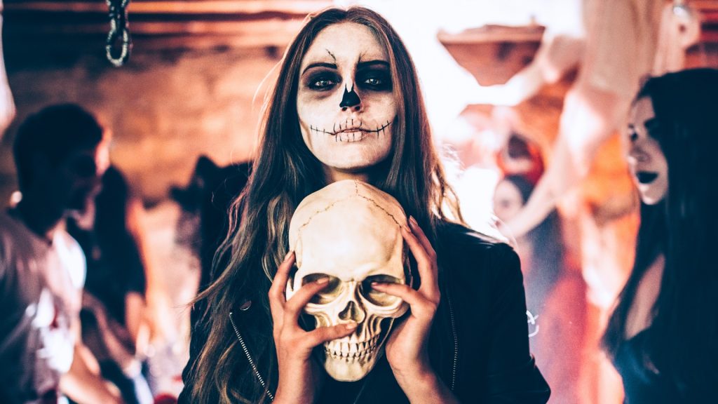 Totenkopf Frau hält einen Schädel in der Hand auf einer Halloween-Party-Ideen