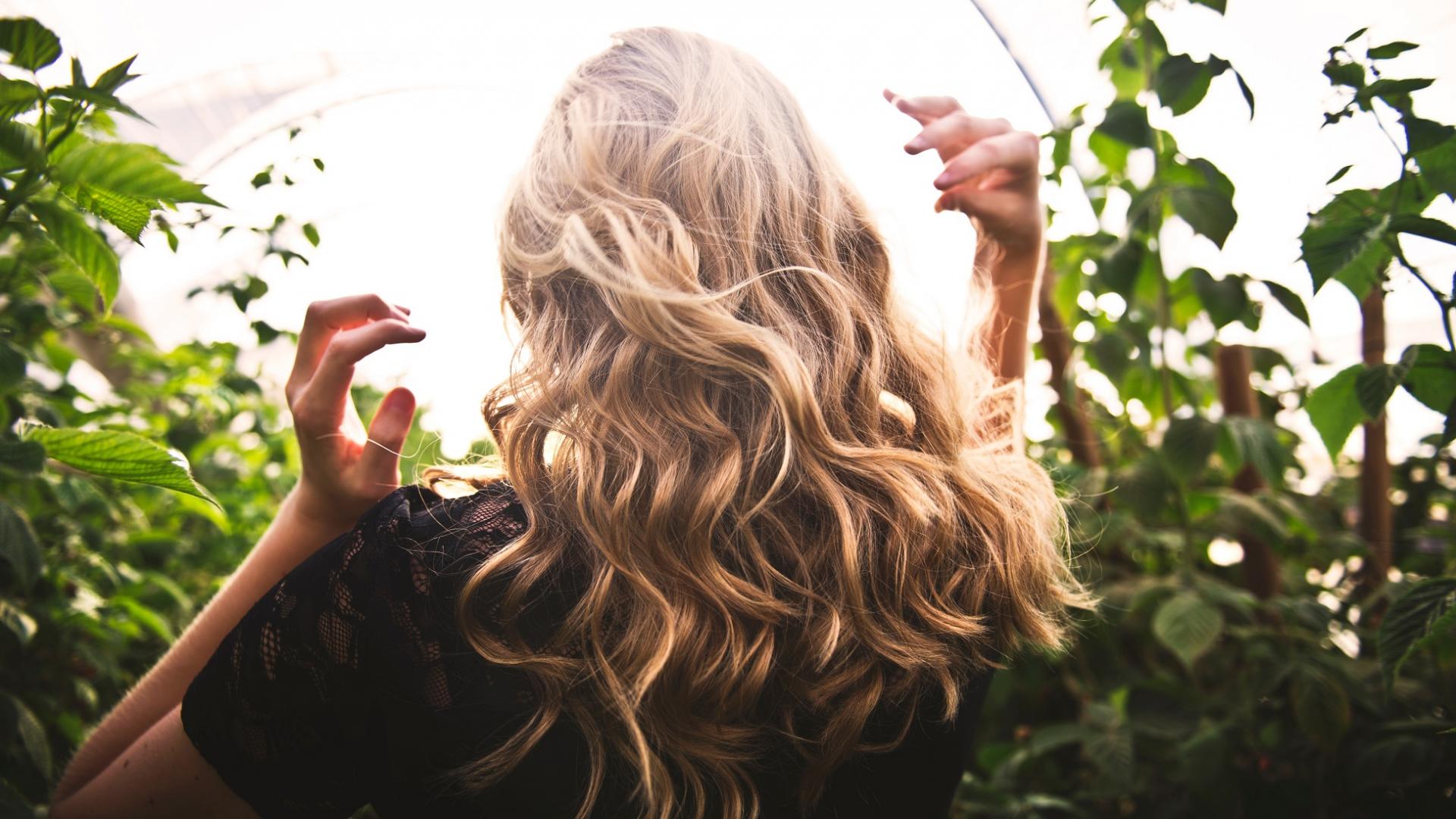 Frau mit blonden Haaren im Garten