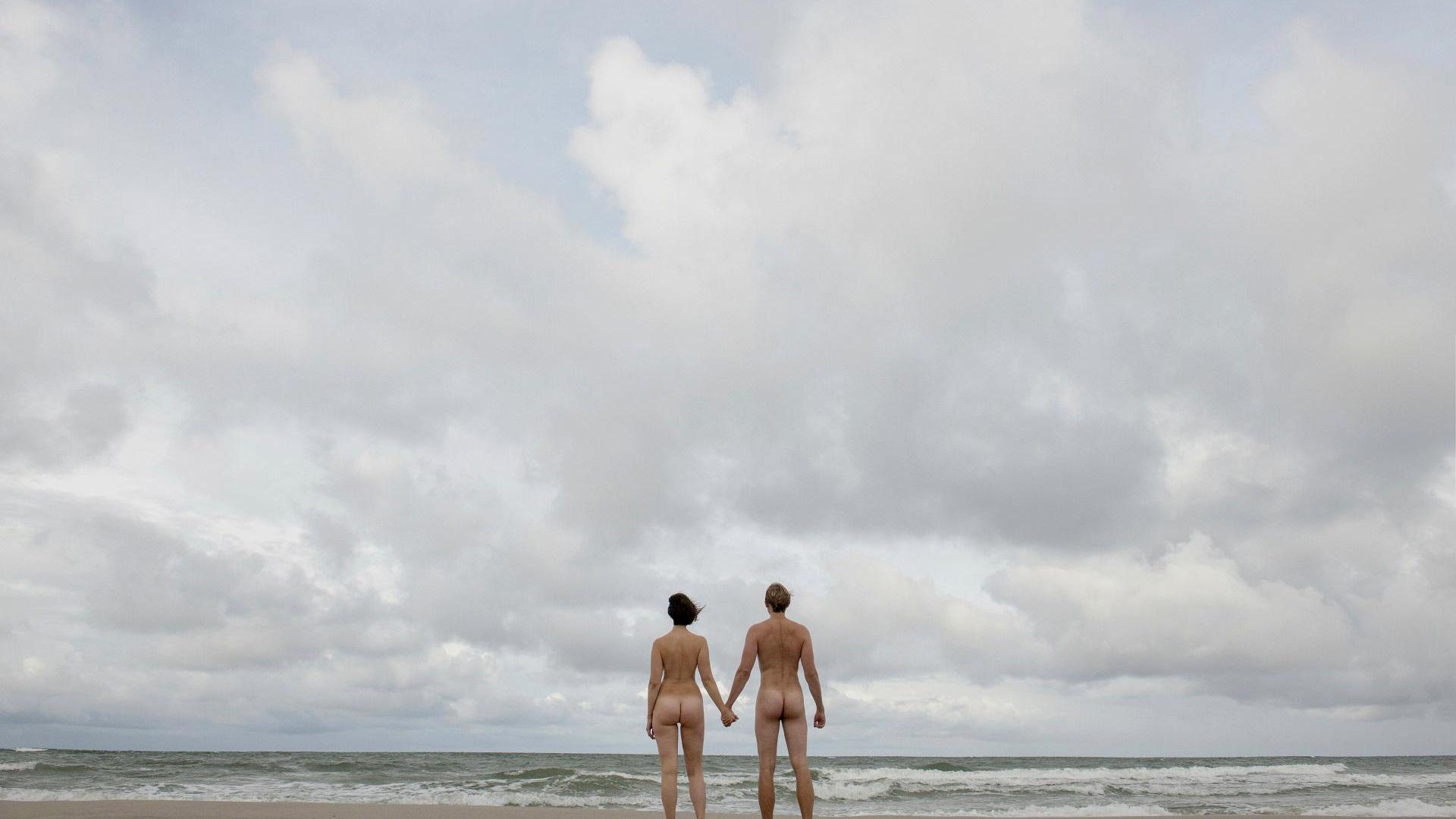 Gleichberechtigung: Mann und Frau halten Hand nackt am Strand