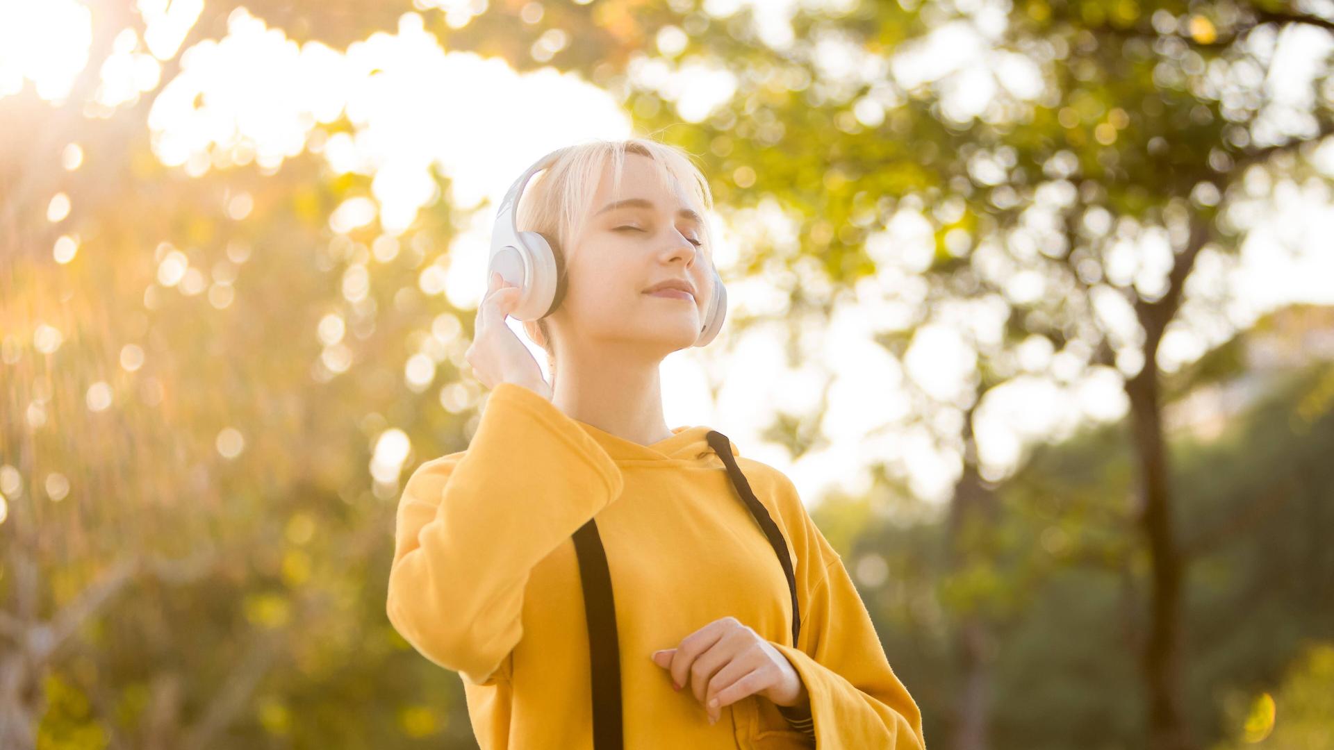 Frau hört Musik in der Sonne
