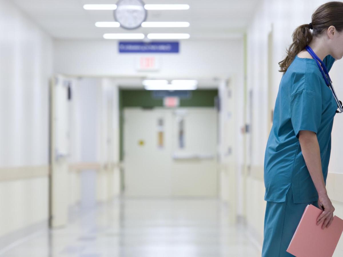 Coronavirus Frau lehnt Kopf an Wand im Krankenhaus