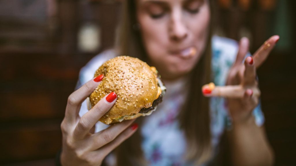 Frau mit Burger in der Hand, Essen