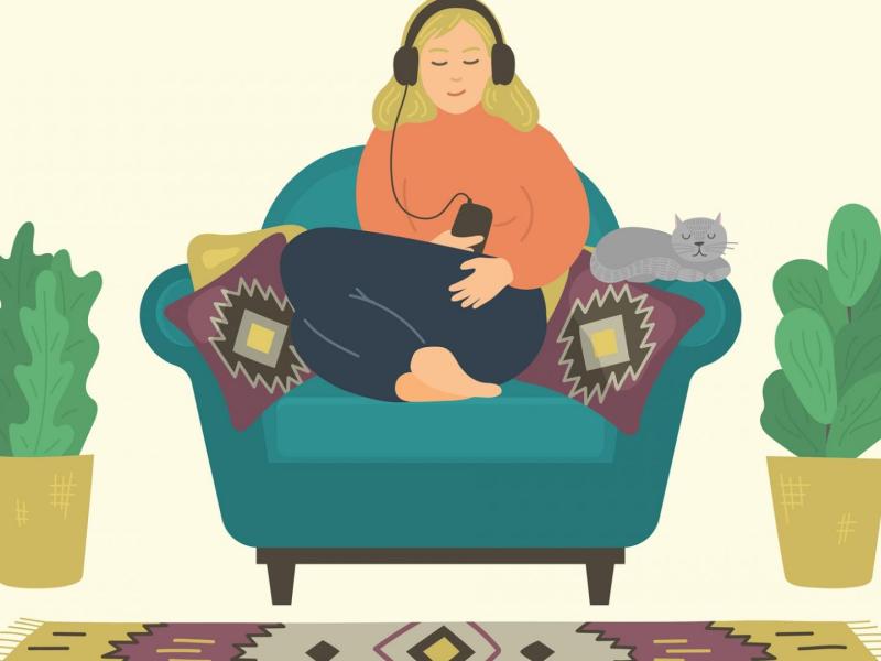 Frau sitzt entspannt auf der Couch und hört mit Kopfhörern Podcasts