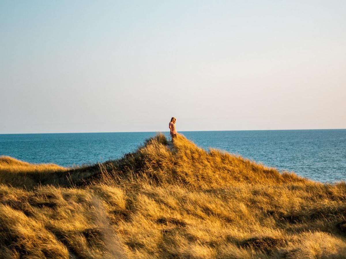 Frau steht auf einer Düne an der Küste