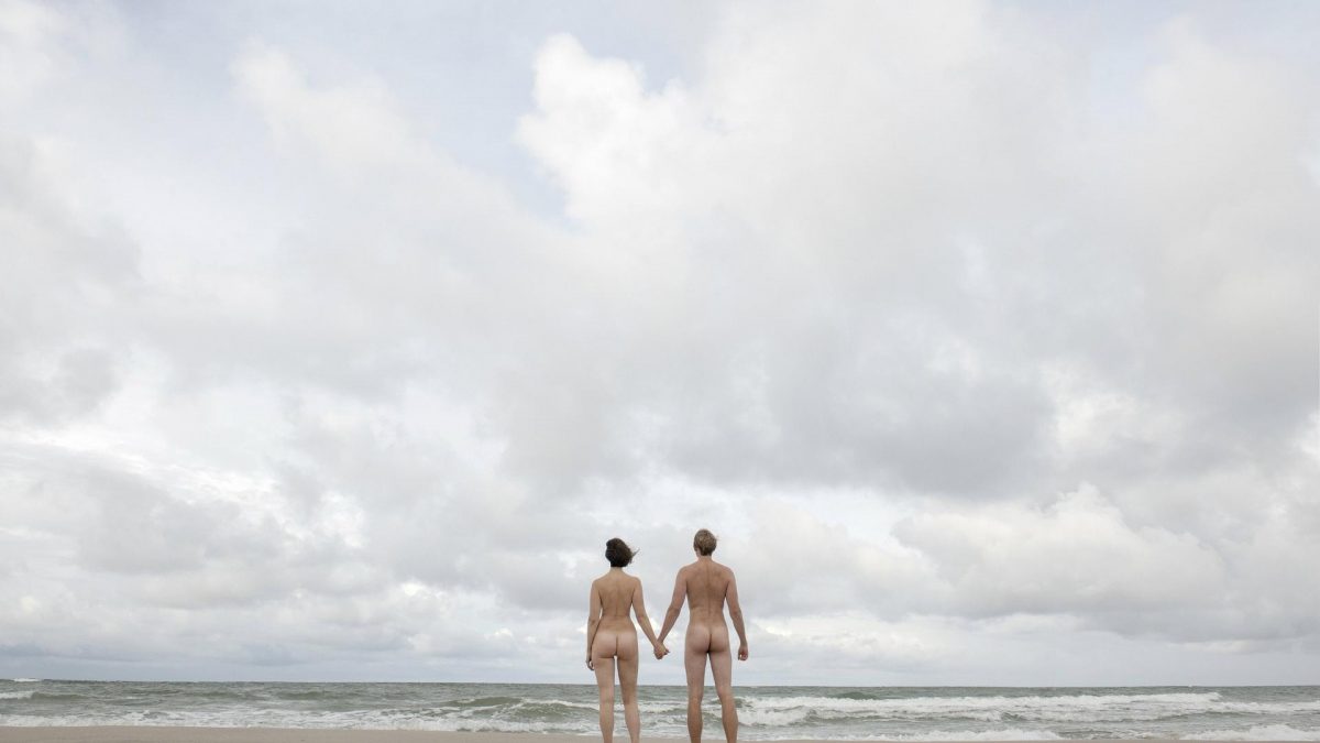 Gleichberechtigung: Mann und Frau halten Hand nackt am Strand