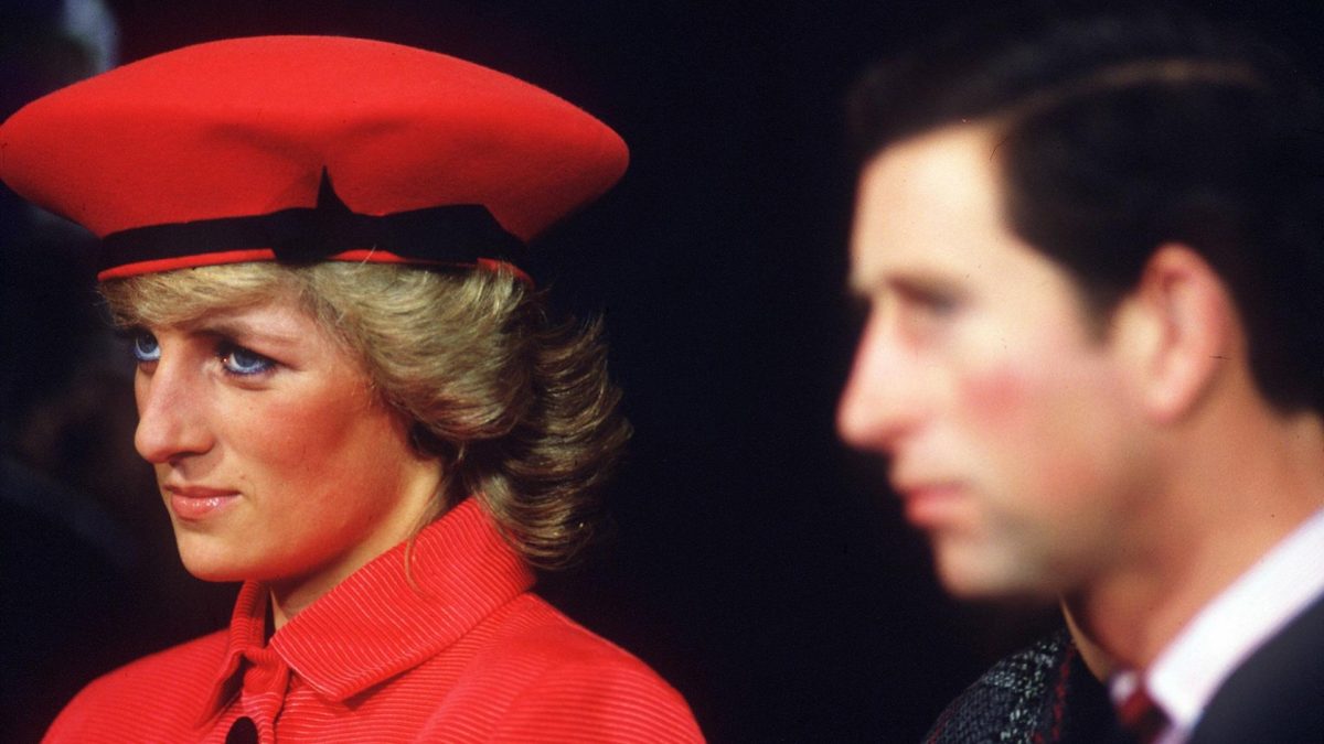 Lady Diana mit roter Mütze und rotem Mantel neben Prinz Charles