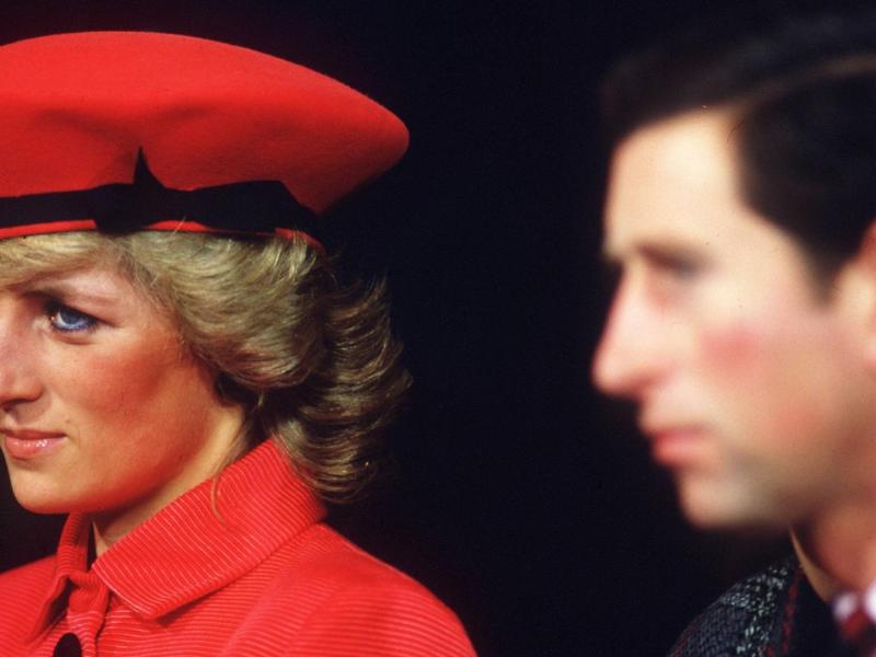 Lady Diana mit roter Mütze und rotem Mantel neben Prinz Charles