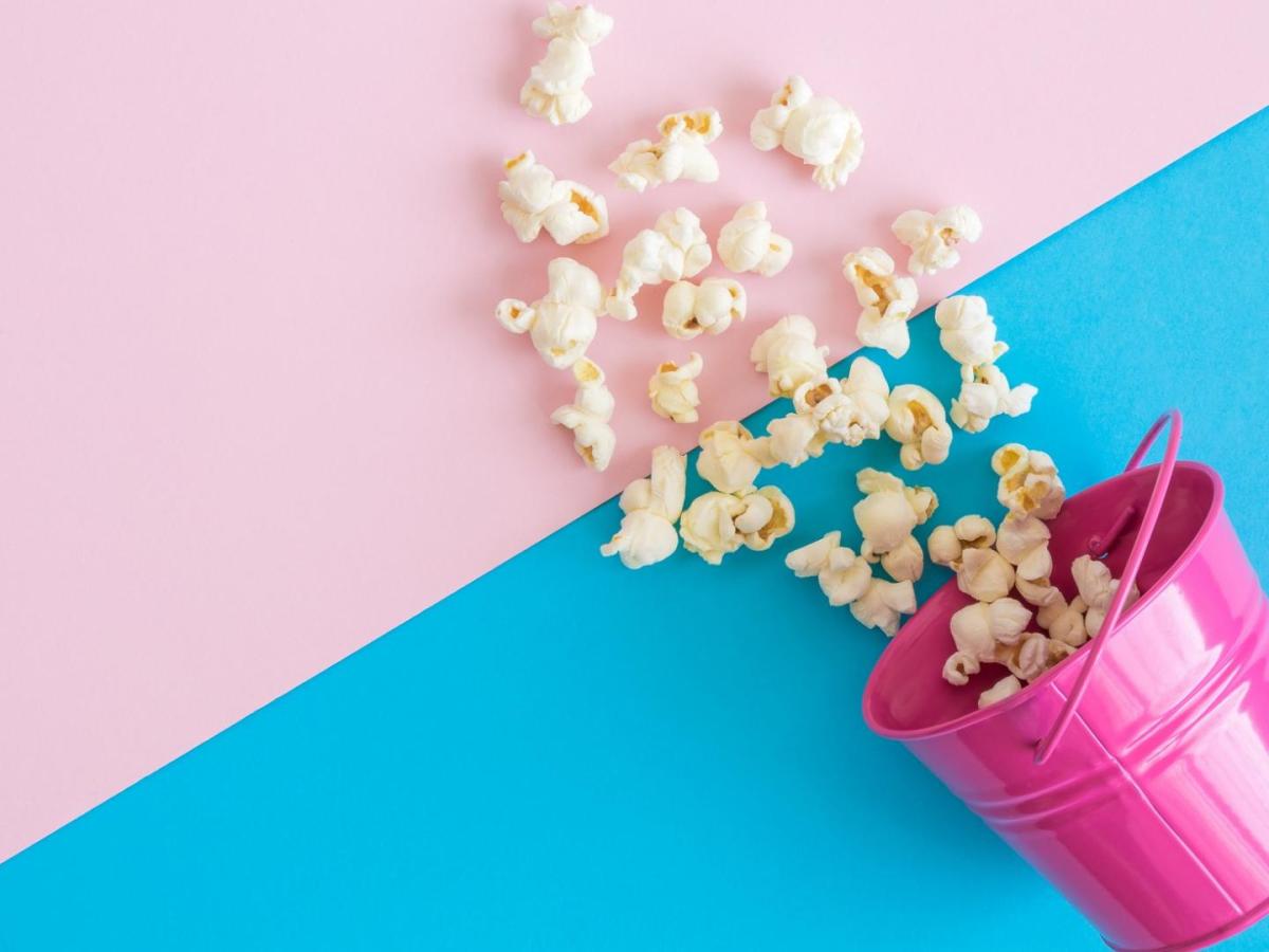 Popcorn in einem rosa Eimer und auf einem rosa-blauen Hintergrund