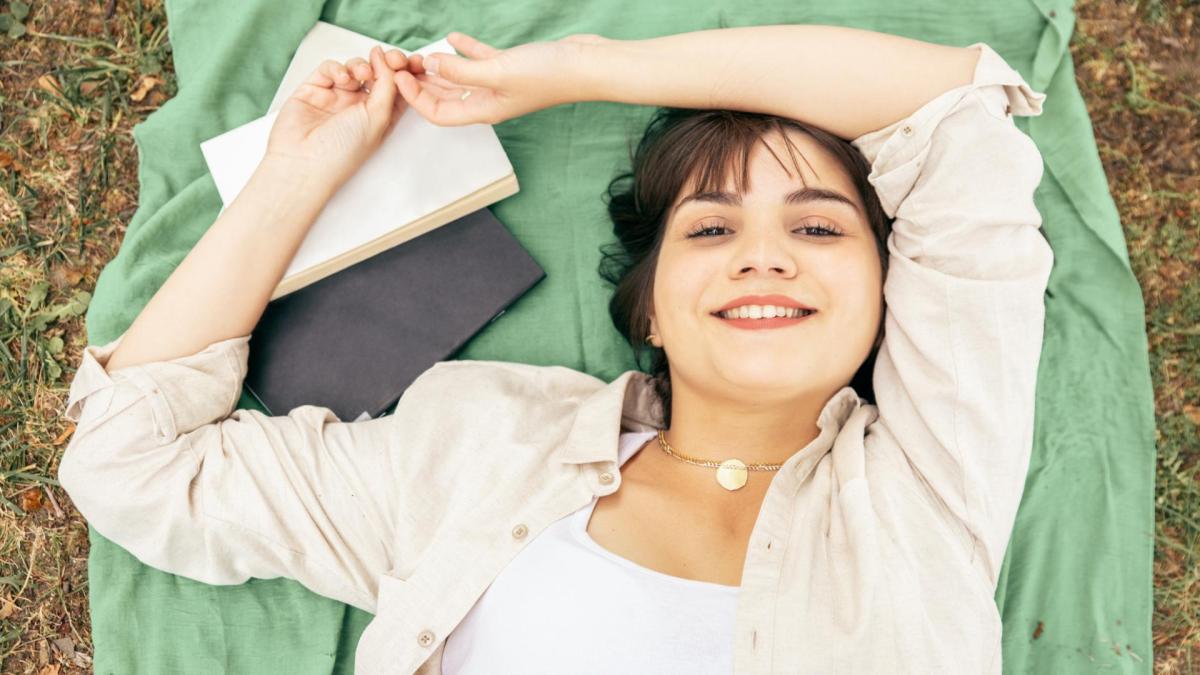 frau studentin grad liegen lernen lächeln plus size