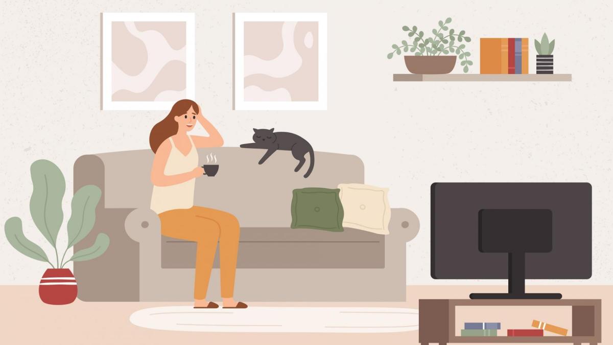 junges Mädchen auf der Couch mit Katze vor dem Fernseher