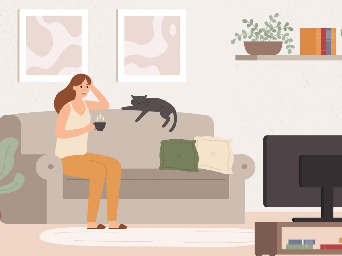 junges Mädchen auf der Couch mit Katze vor dem Fernseher