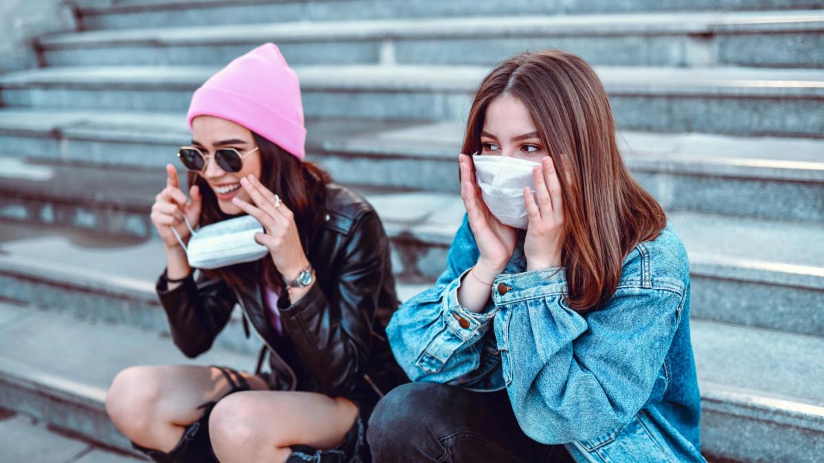 zwei junge Frauen tragen Masken