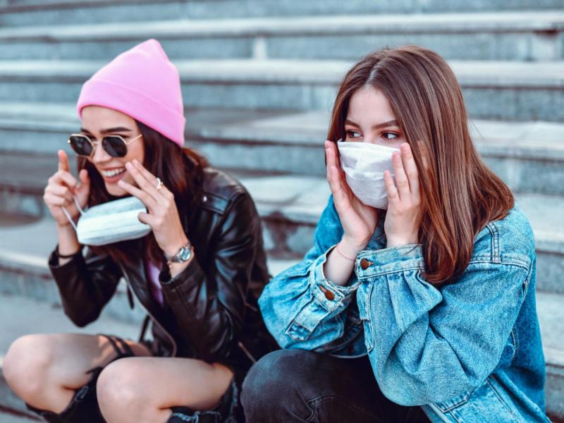 zwei junge Frauen tragen Masken
