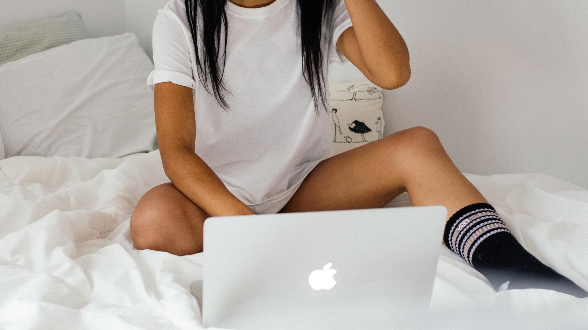 Frau im Bett am Computer, Apple