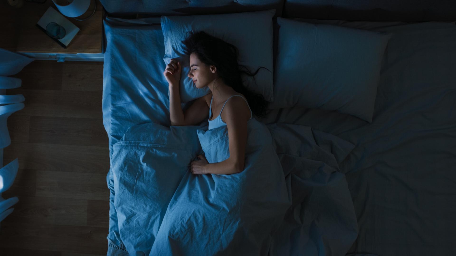 Vogelperspektive auf junge Frau in seinem Schlafzimmer bei Nacht