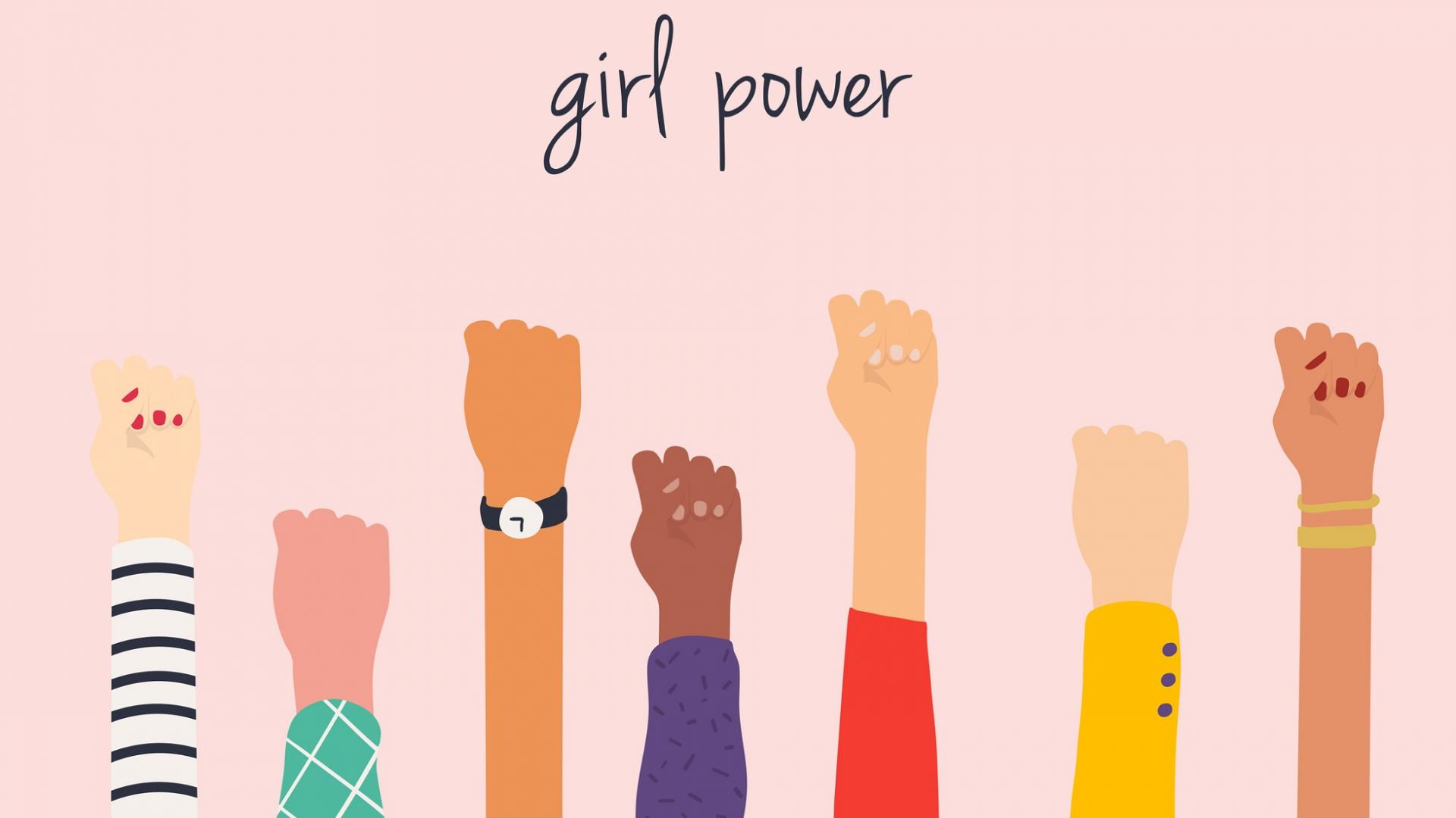 Bild zeigt erhobene weibliche Fäuste als Symbol für Girlpower vor rosafarbenen Hintergrund