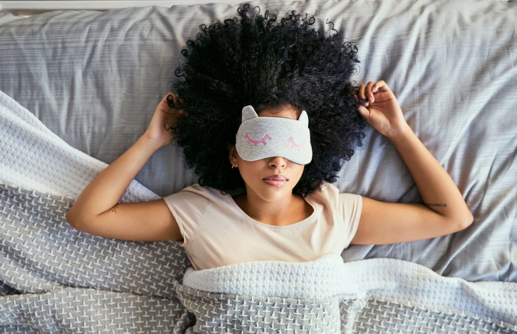 Shot of a young woman sleeping with a mask on in bed Lebenserwartung berechnen