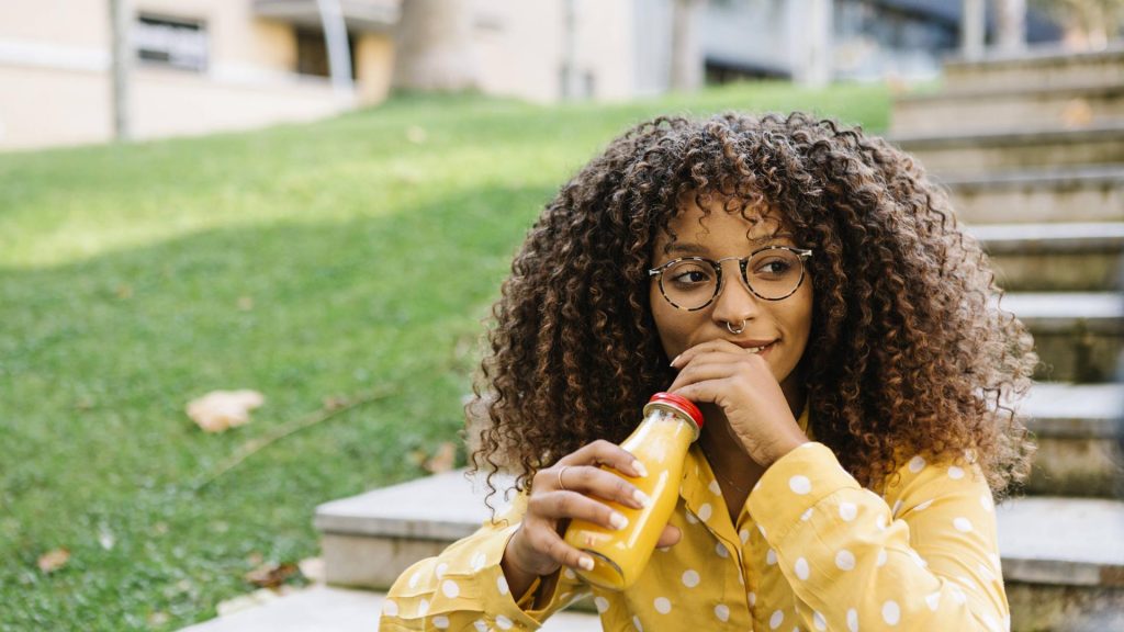 heilfasten saft kur frau schwarz afro draußen trinken