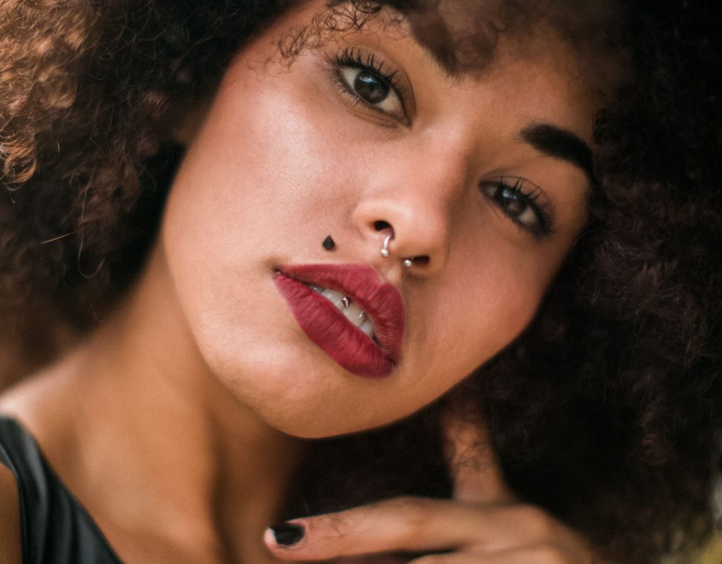 schwarze frau mit nasenpiercing afro makeup und schöhnheitsfleck