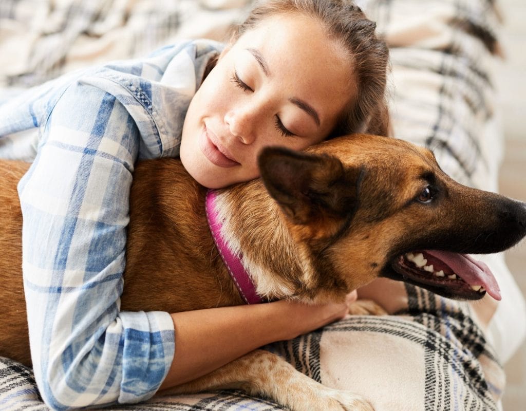 Frau kuschelt mit Hund. Liebt mich mein Hund?