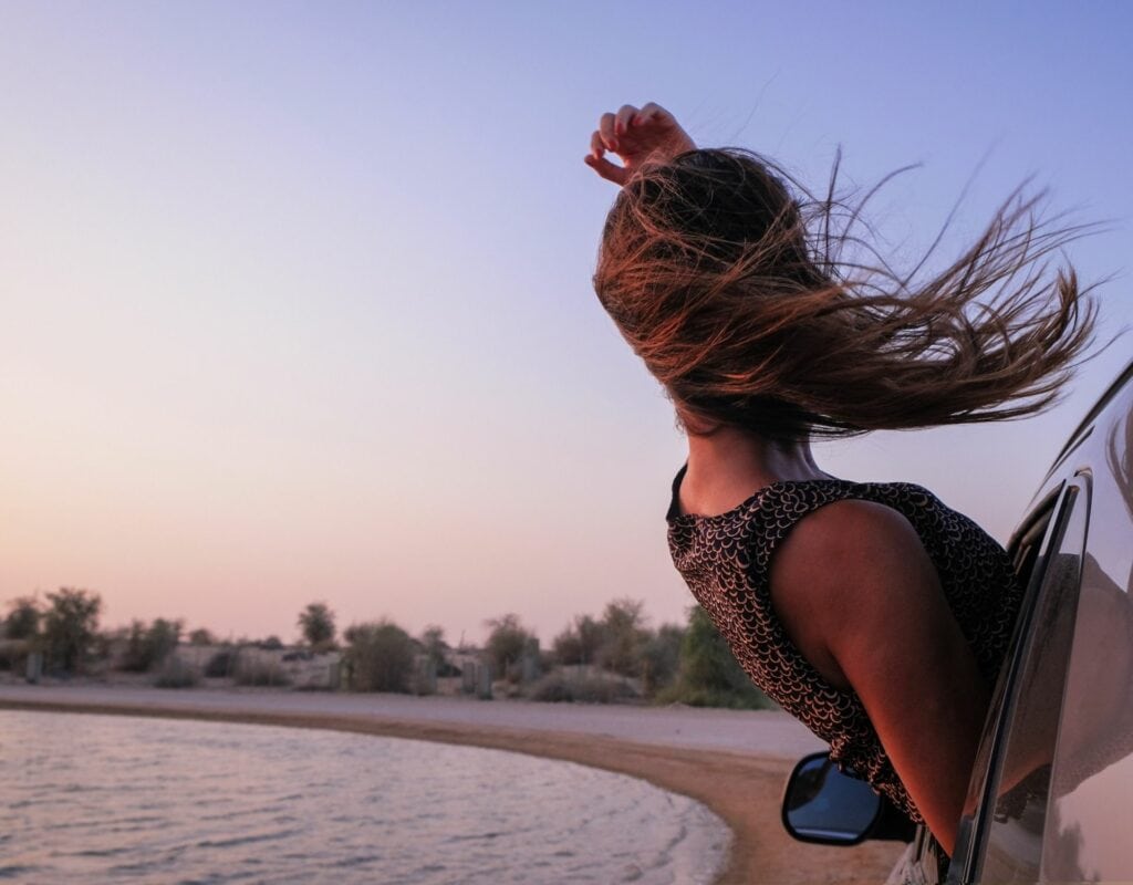 Femme dans la voiture pendant le coucher du soleil.  Exercices d'amour de soi