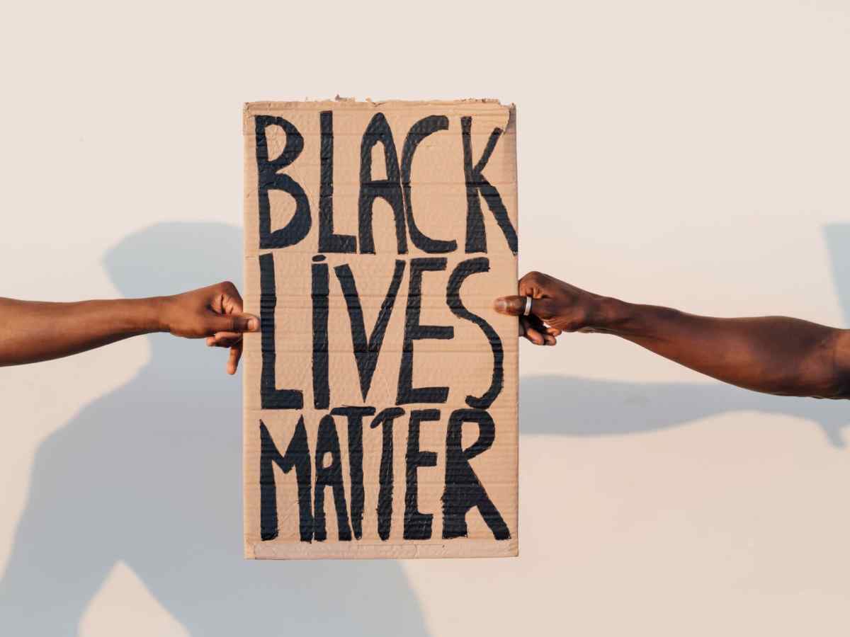 Zwei Schwarze halten BLM Schild