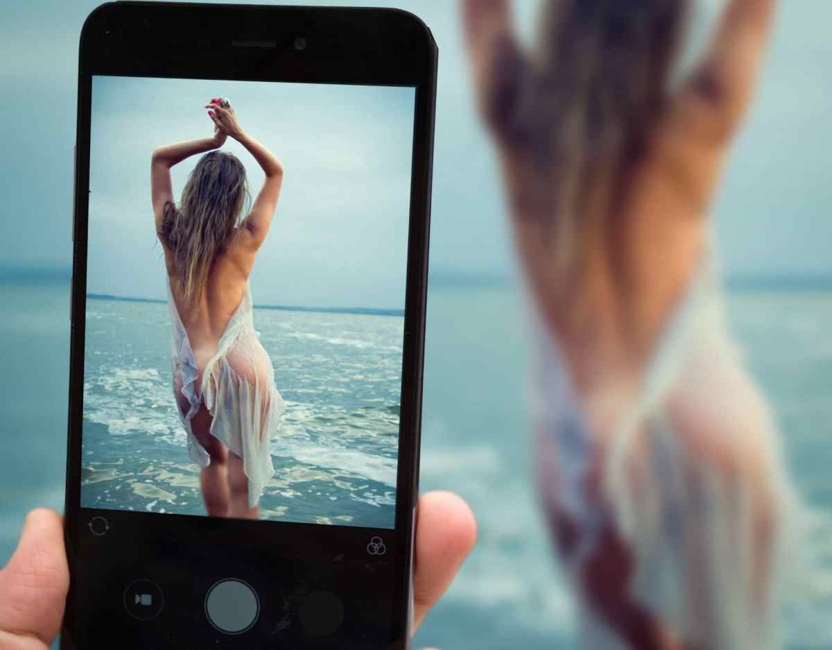frau nackt am strand selfie mit smartphone