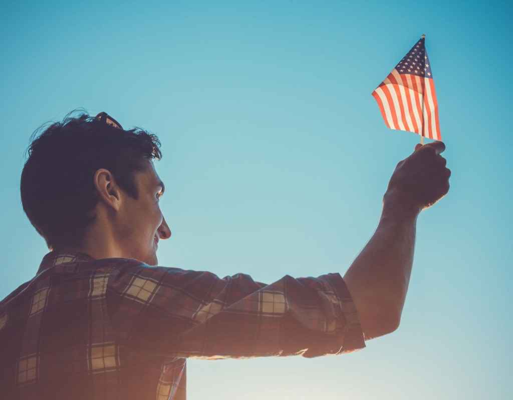 mann hält eine usa flagge in die luft