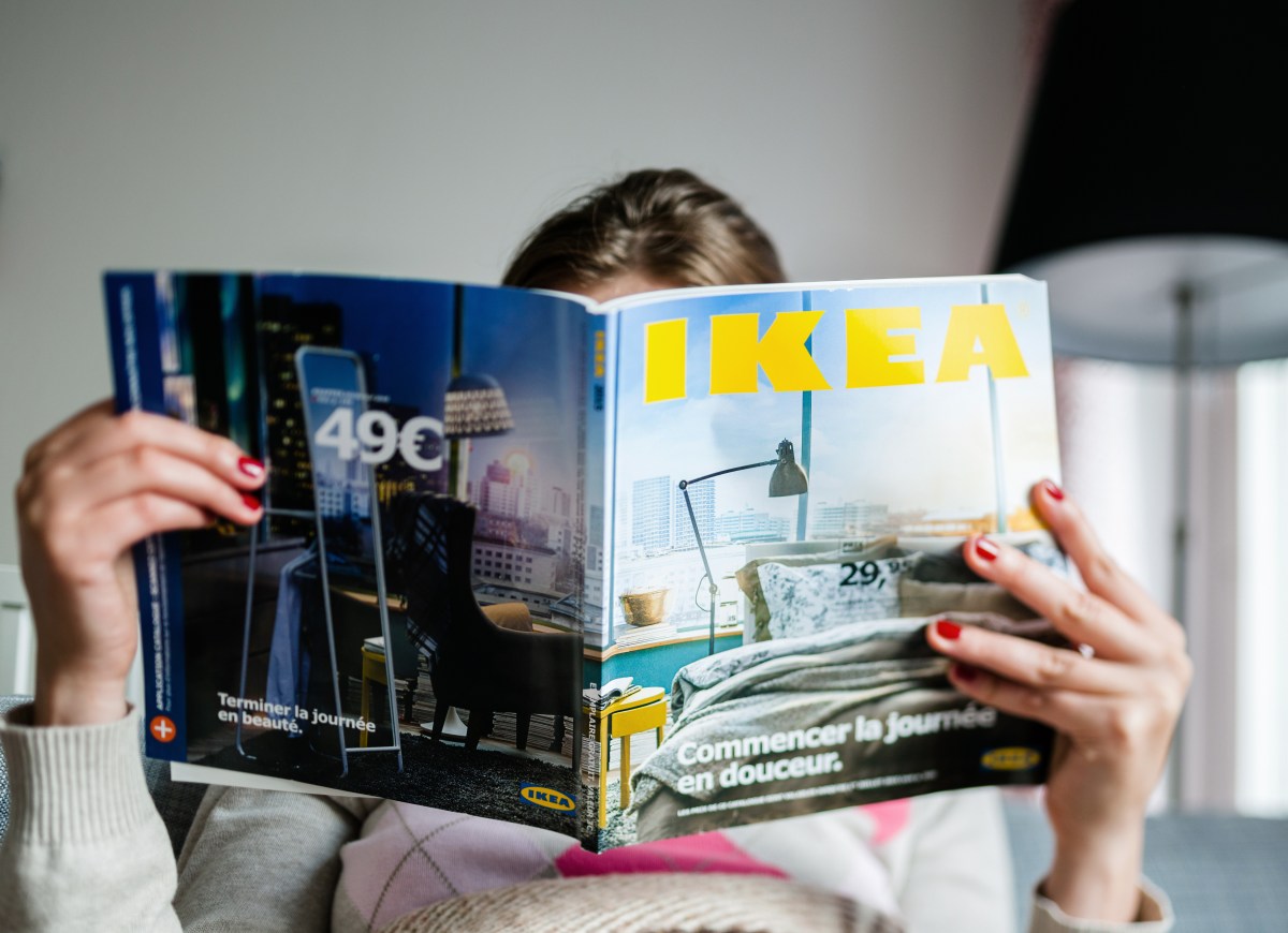 Frau schaut in einen IKEA-Katalog