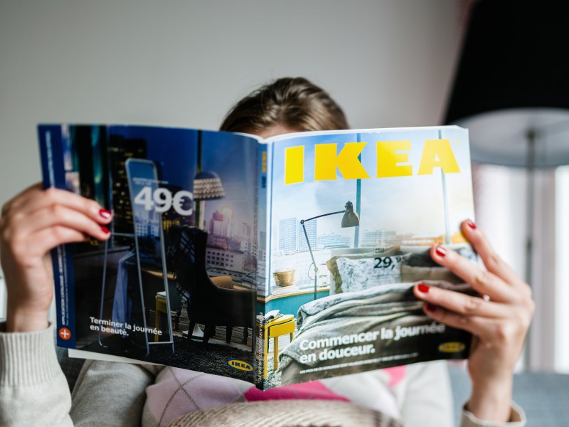Frau schaut in einen IKEA-Katalog