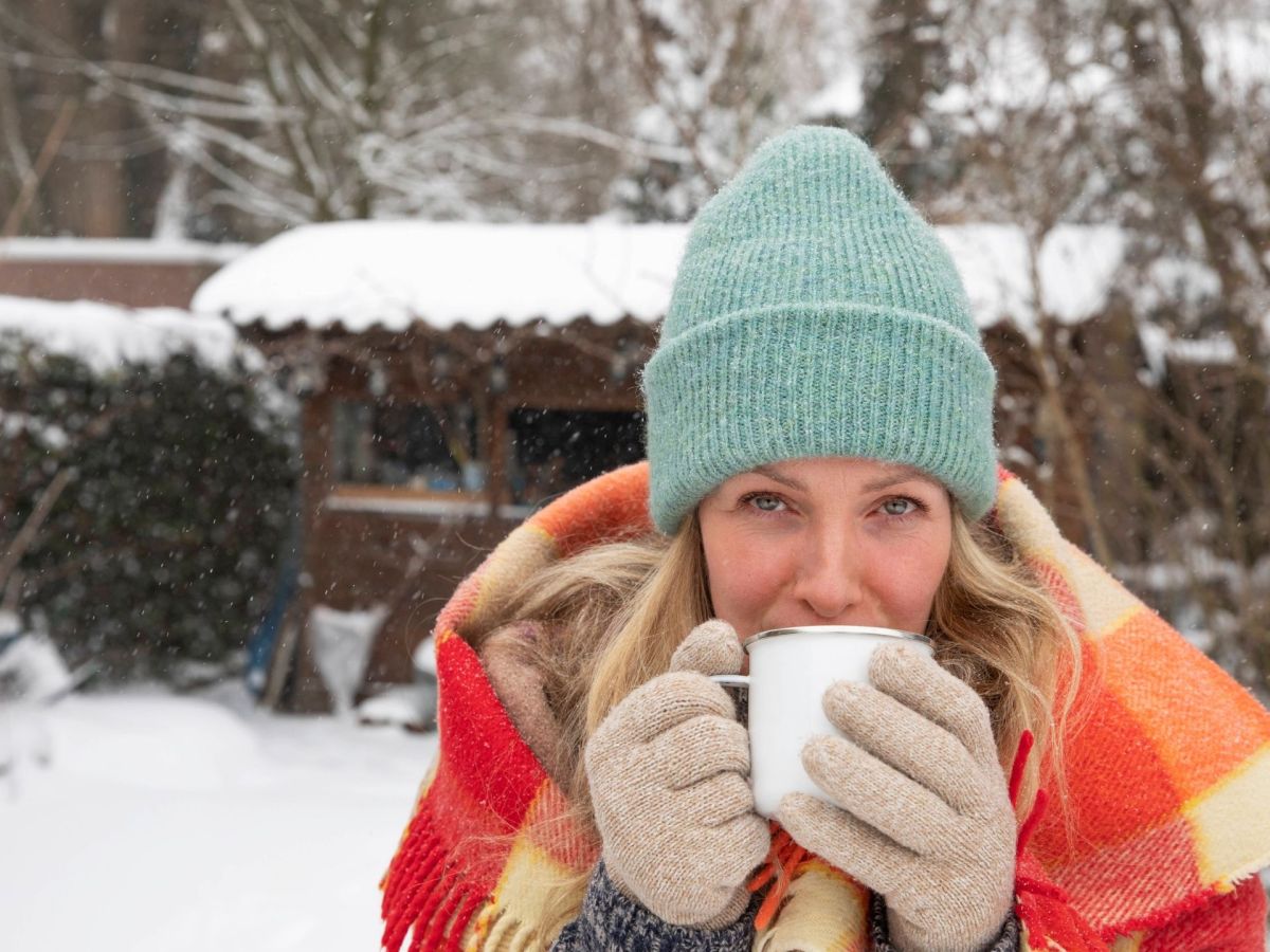 Frau trinkt Kaffee im Schnee