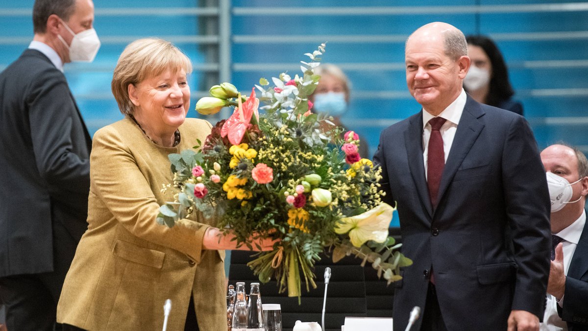 Angela Merkel freut sich über die Abschiedsblumen von Olaf Scholz.. © imago/Bildgehege