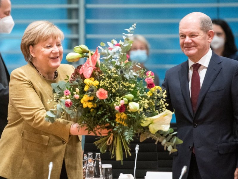 Angela Merkel freut sich über die Abschiedsblumen von Olaf Scholz.. © imago/Bildgehege