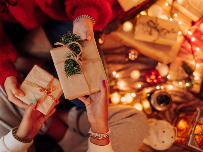 Hände, die sich Geschenke überreichen