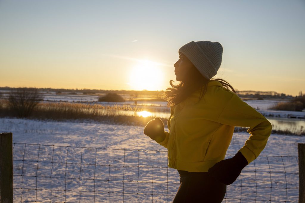 Frau joggt durch Schnee