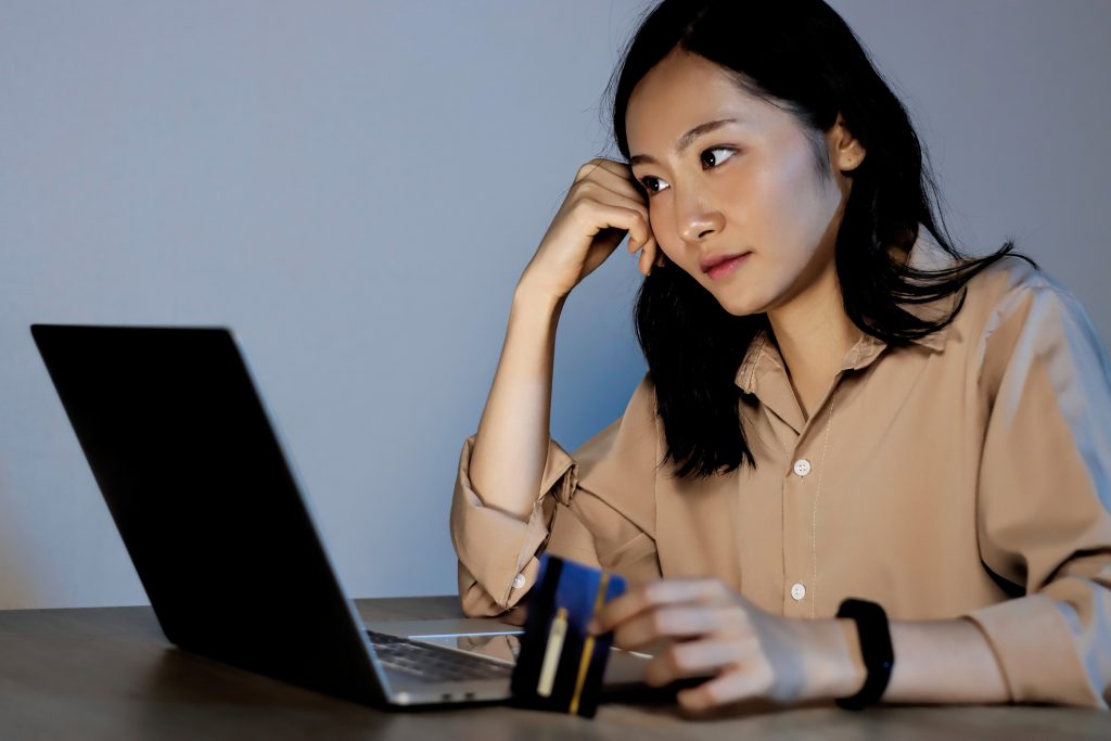 frau asiatisch laptop kreditkarte bezahlen businessYoung woman holding credit card and using laptop computer. Businesswoman working at home. Online shopping, e-commerce, internet banking, spending money, working from home concept