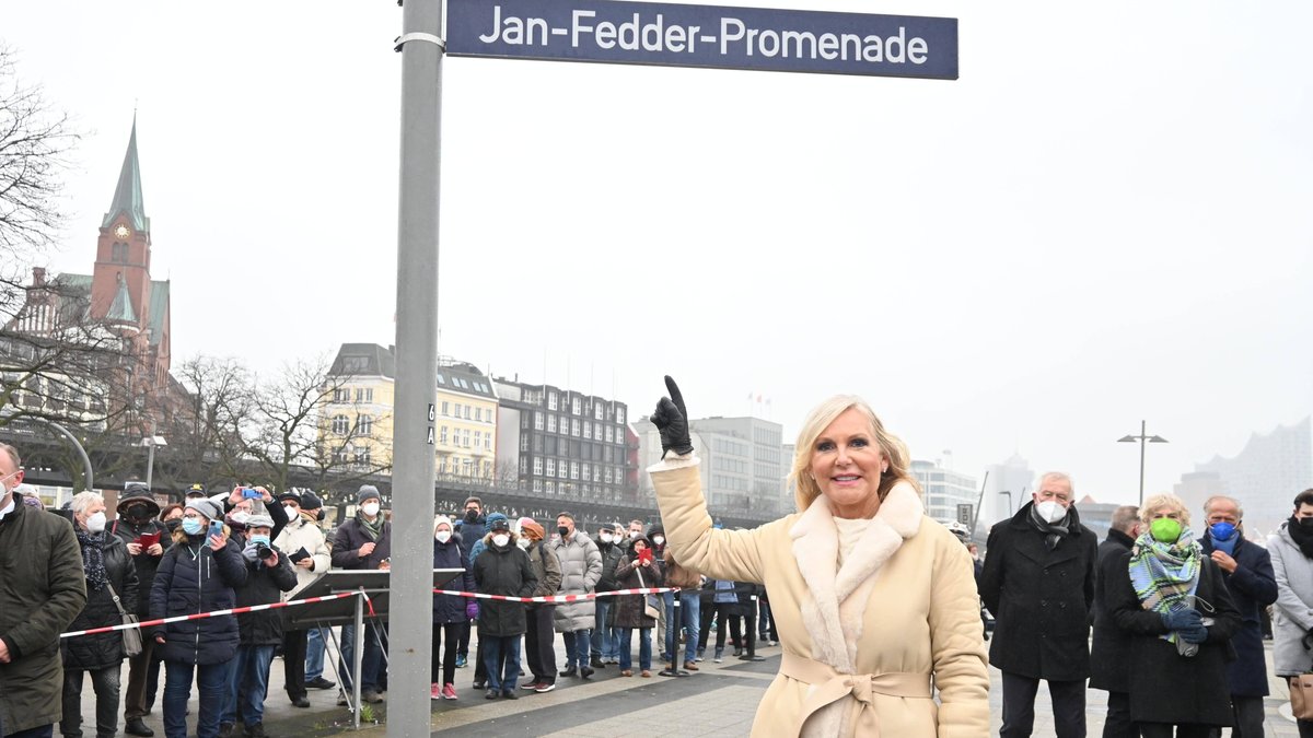 Witwe Marion Fedder unter dem neuen Straßenschild der Jan-Fedder-Promenade.. © imago/Andre Lenthe