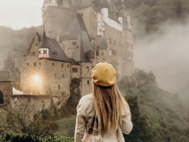 Frau steht vor Schloss