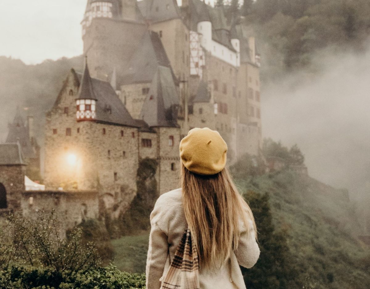 Frau steht vor Schloss