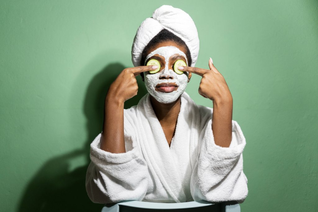 Frau mit Maske und Gurken im Gesicht