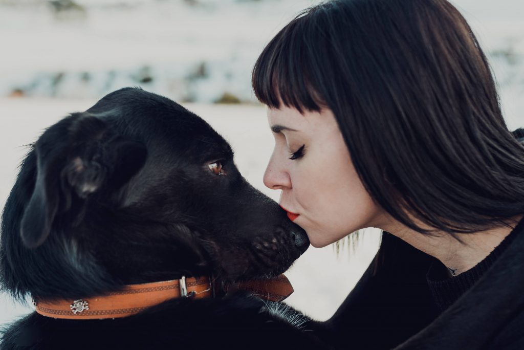 Frau küsst Hundenase