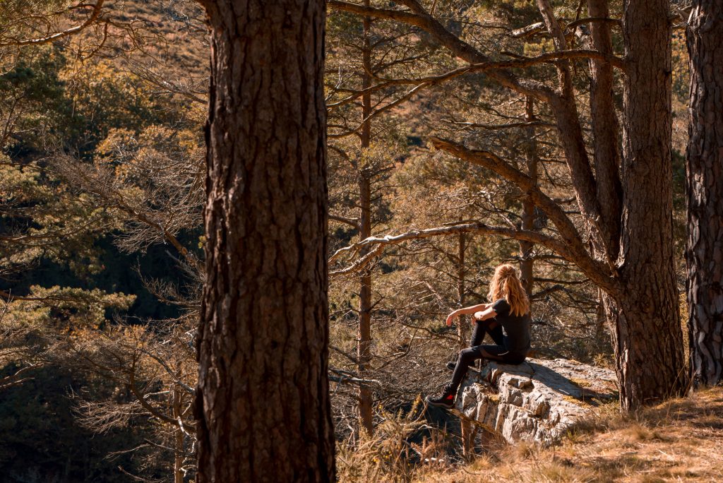 Frau sitzt im Wald