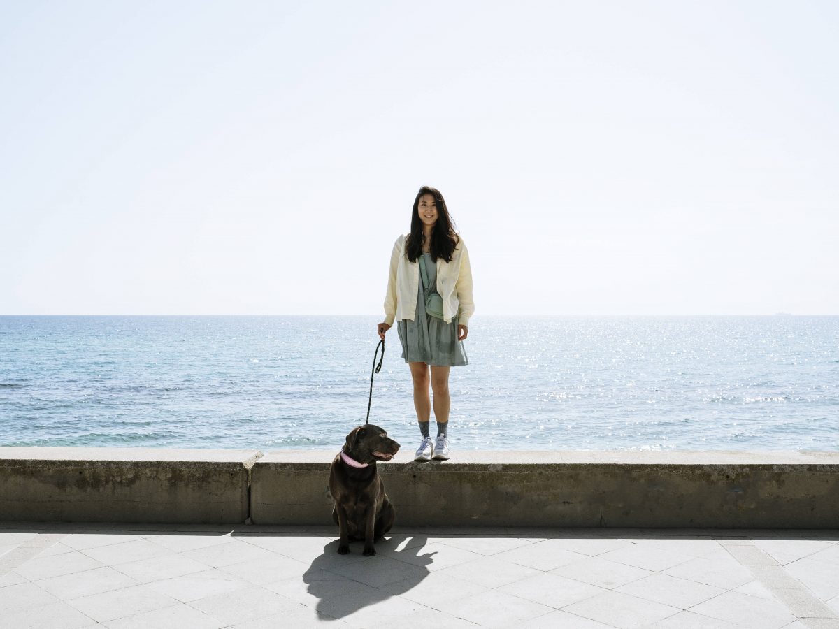 Frau mit Hund am Meer