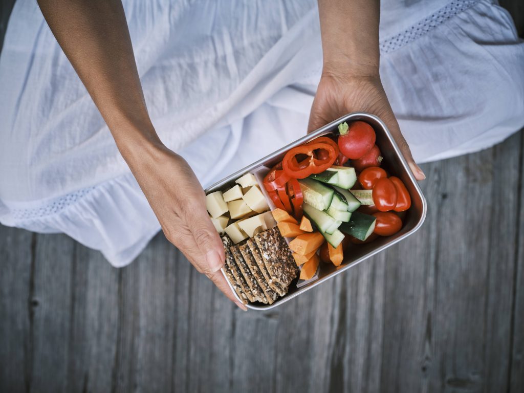 Woman eating healthy vegetables sleepy in hand