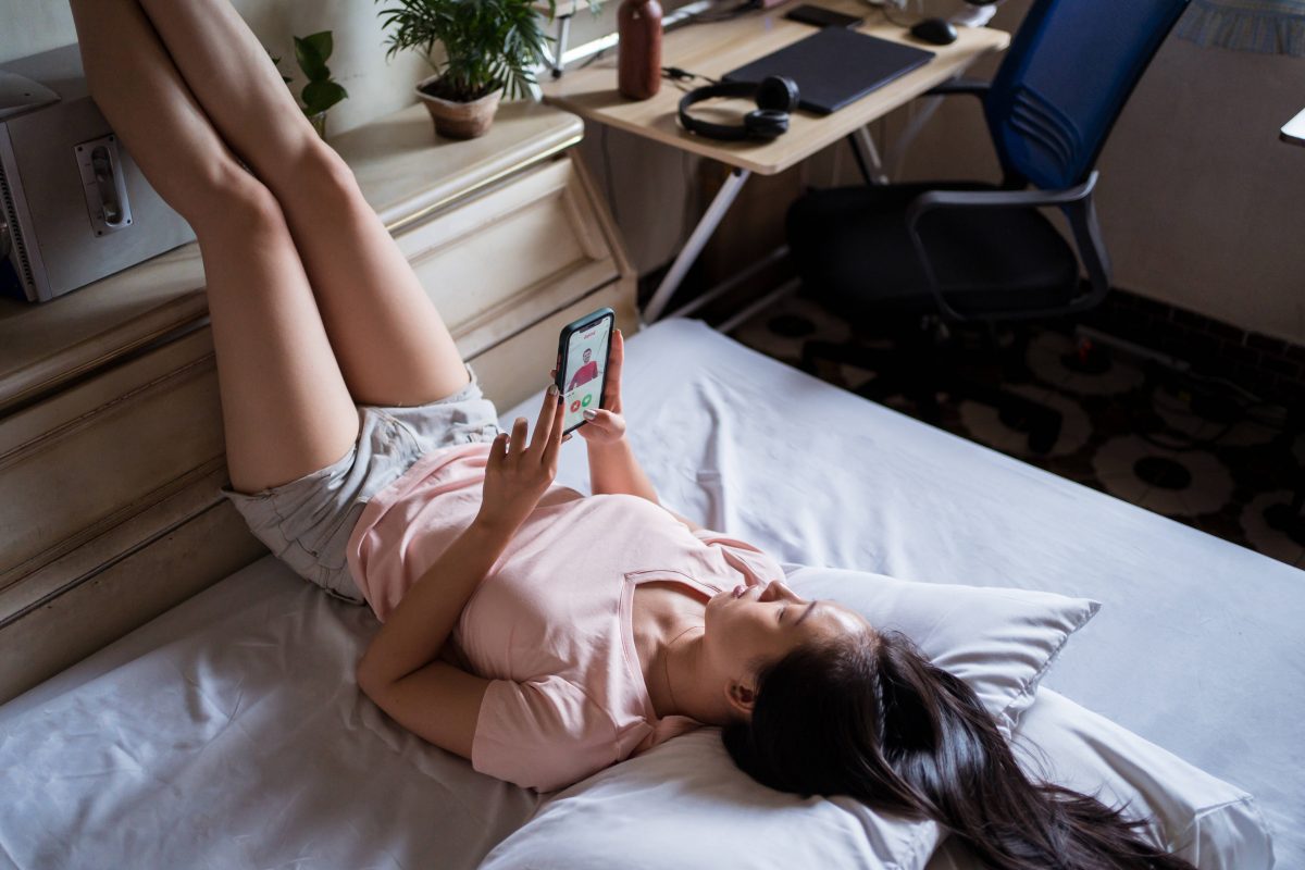 Frau im Bett mit Handy